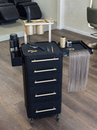 Black hair styling cart with tools and supplies in a salon setting